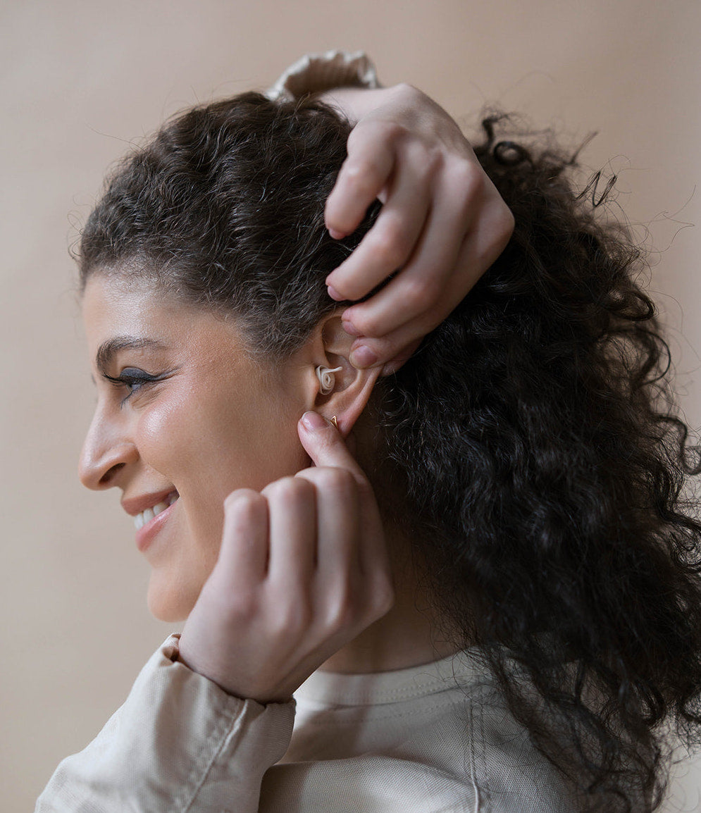 girl wearing earpeace everyday earplug in cream