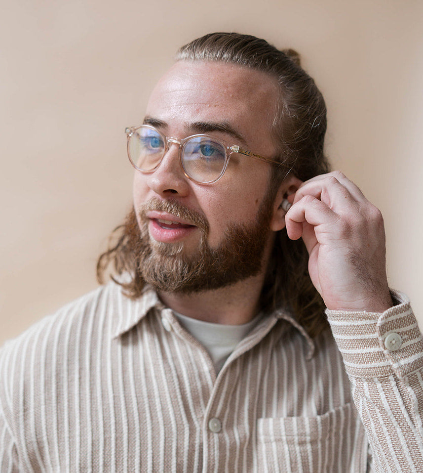 guy wearing earpeace everyday earplug in cream