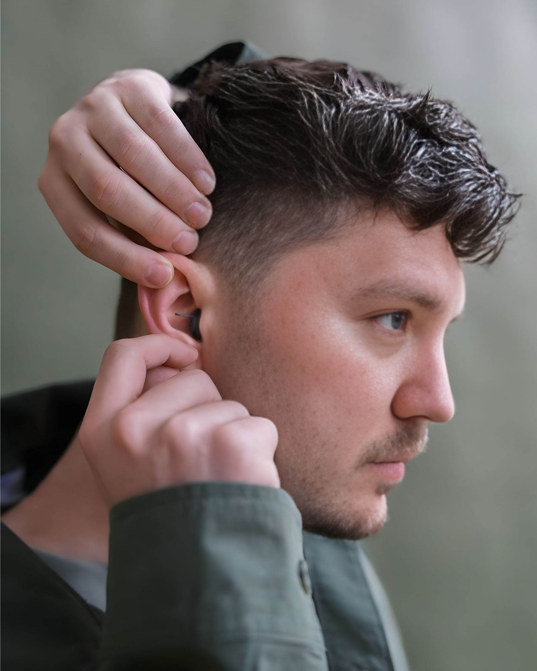 guy wearing earpeace everyday earplug in forest #color_forest