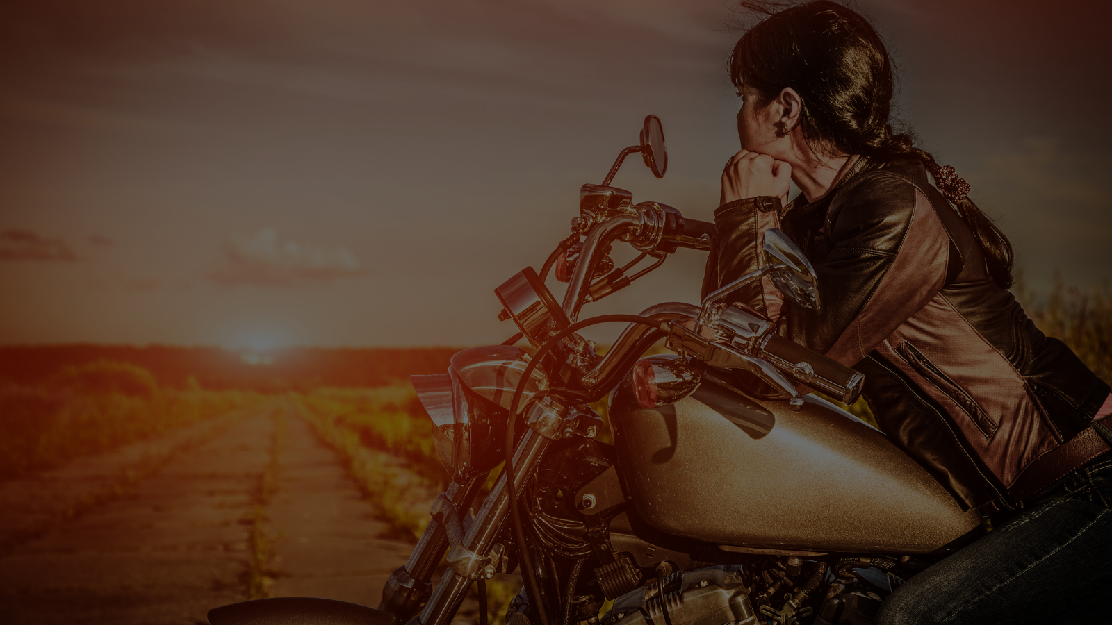 woman on motorcycle with the sun setting