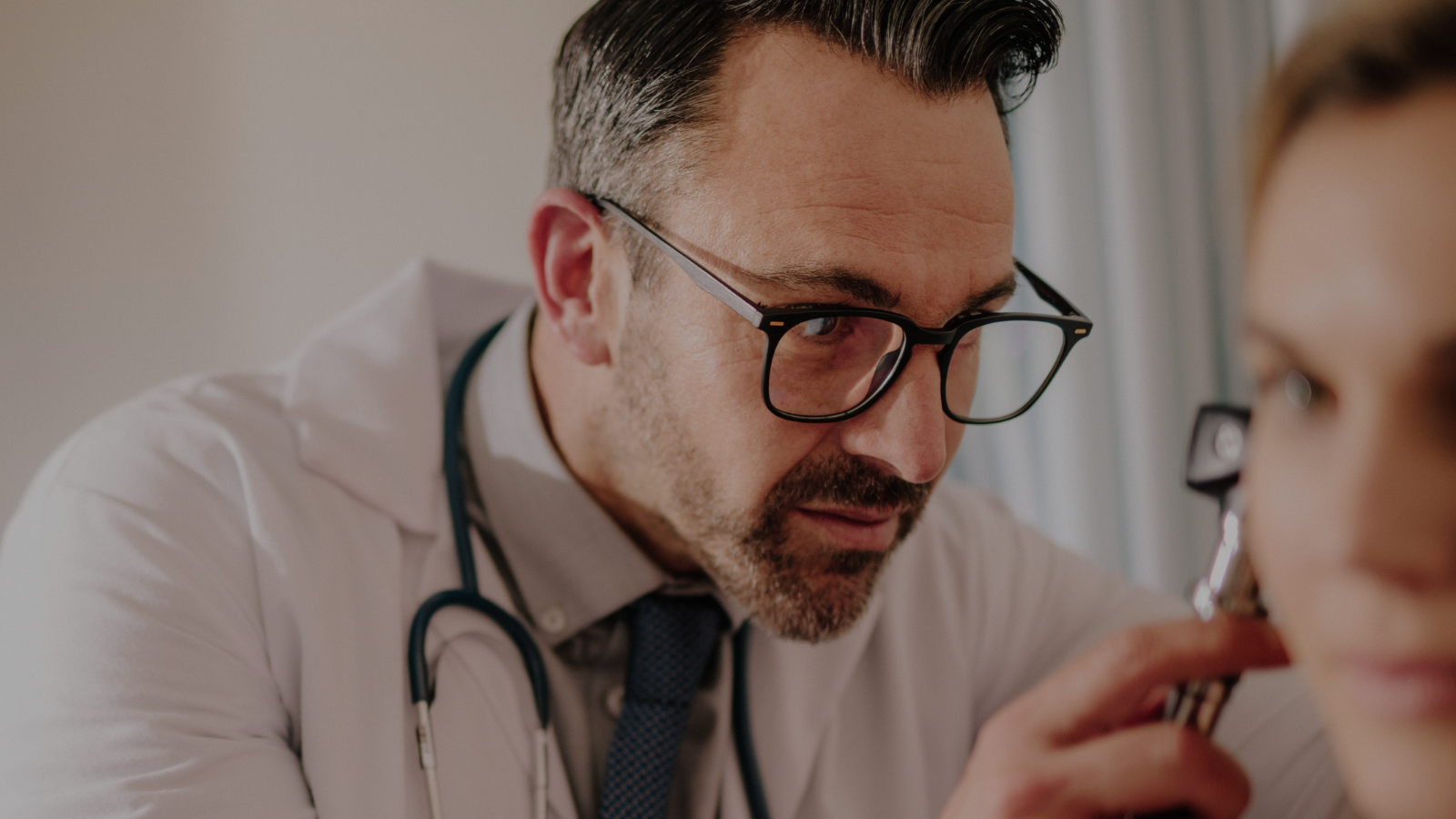 Audiologist examining a woman's ears