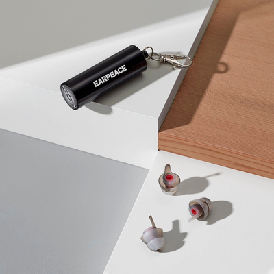 Black 'EARPEACE' carrying case on a white surface with a set of EARPEACE earplugs