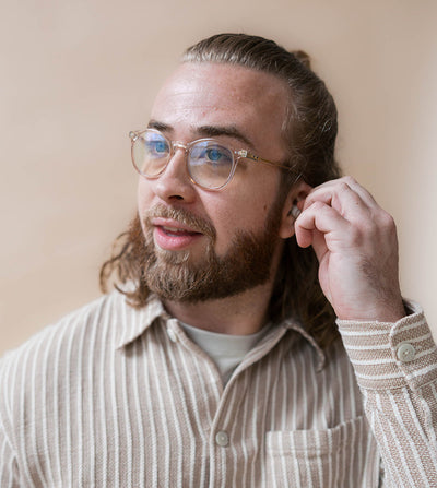 guy wearing earpeace everyday earplug in cream